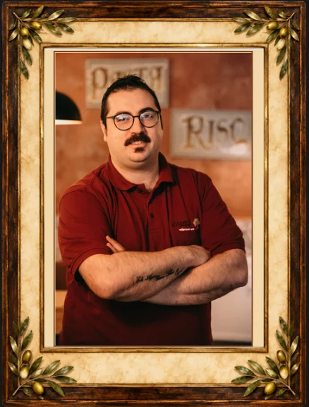 Teammitglied mit Brille im roten Poloshirt der Osteria Antico Il Mattone